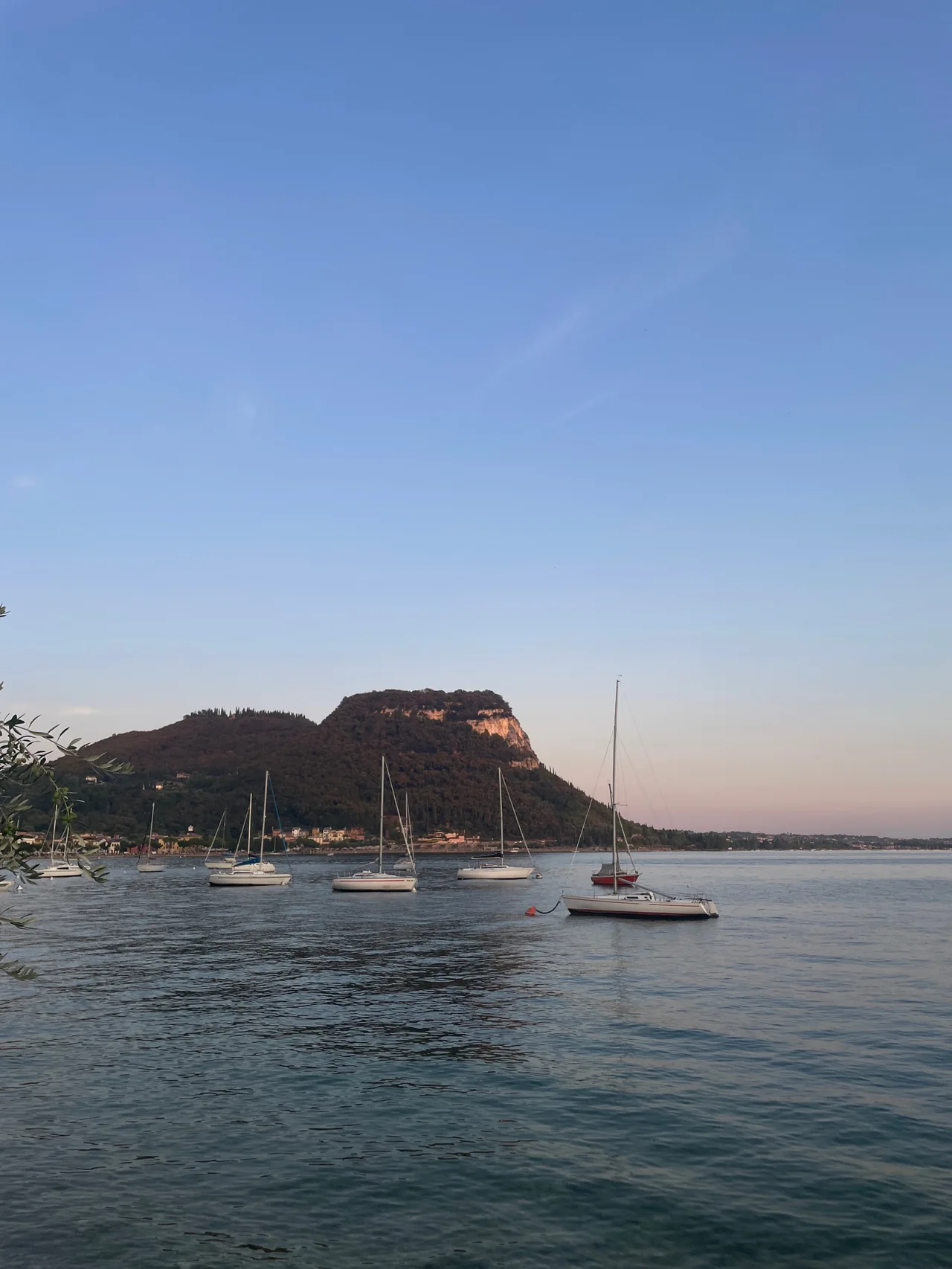 Boats moored off the shore of Lake Garda at dusk